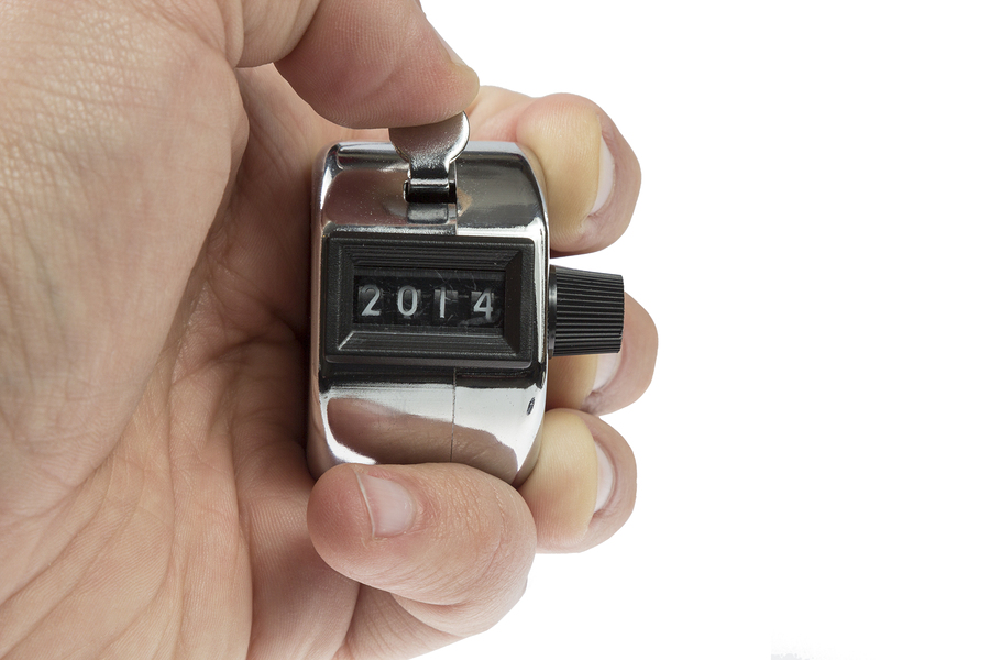 Hand held tally counter showing 2014 holded by male hand isolated on white background