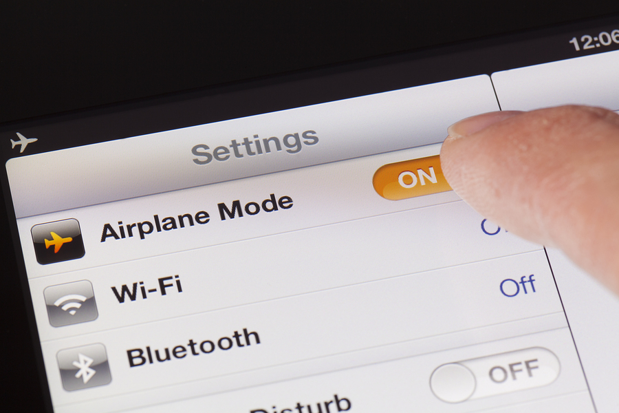 Adelaide, Australia - October 3, 2012: Switching to Airplane mode on an iPad. Airplane mode is a setting on iPhone and ipad that. when switched on, will disable the device's capacity to place or receive calls or text messages.